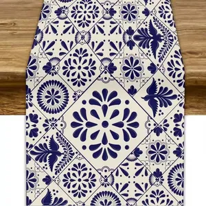 Detail view of a premium linen table runner featuring blue Mexican floral and bird patterns.