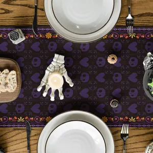 Chemin de table Jour des Morts avec motifs de têtes de mort violets en situation