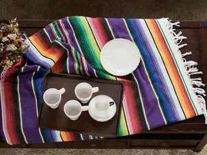 Close-up of a Mexican serape table runner with vibrant stripes and fringes