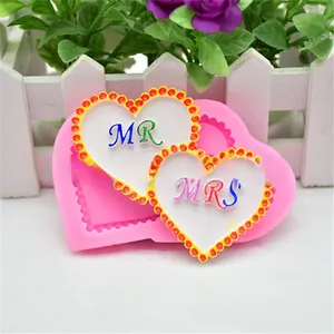 Detailopname van hart siliconen mal met MR en MRS fondant decoraties
