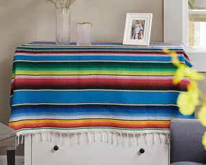 Authentic Mexican serape tablecloth featuring vibrant rainbow stripes and white fringe tassels