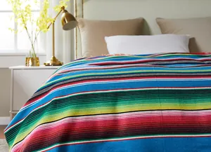 Close-up of vibrant Mexican striped fabric used as a decorative bed runner