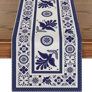 Detailed view of the blue and white Talavera bird and flower pattern on a linen table runner