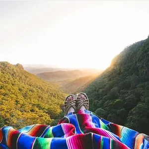 Colorful Mexican serape table runner styled as a cozy blanket overlooking a scenic valley