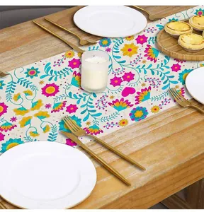 Close-up detail of Mexican style floral print linen table runner on a rustic wooden dining table