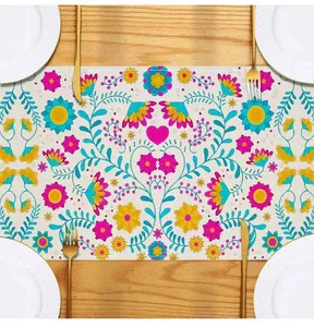 Detailed view of Mexican style floral print table runner on wooden table with plates