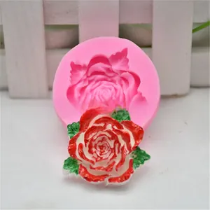 Gedetailleerd zicht op een roze siliconen mal voor rozen en de afgewerkte decoratie.