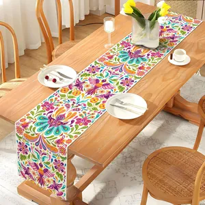 Détail du chemin de table mexicain Jour des Morts avec motifs floraux et oiseaux colorés.