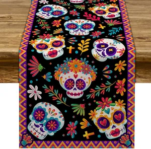 Detailed sugar skull and floral patterns on Day of the Dead themed table runner fabric.