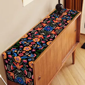 Détail du motif floral et de crâne coloré sur un chemin de table en lin noir