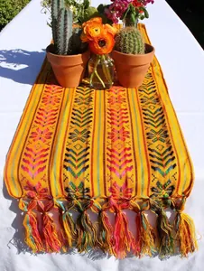 Chemin de table mexicain à rayures colorées et glands décoratifs sur table blanche