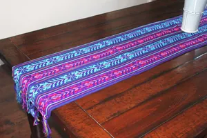 Détail de la texture tissée et des glands du chemin de table mexicain coloré à rayures