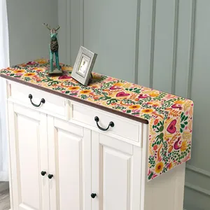 Detalle de camino de mesa mexicano del Día de Muertos sobre un mueble de madera blanco