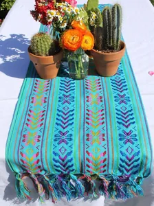 Vue détaillée du chemin de table mexicain coloré avec motifs tissés artisanaux et pompons