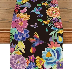 Detalle del camino de mesa del Día de los Muertos con estampado de flores y colibríes