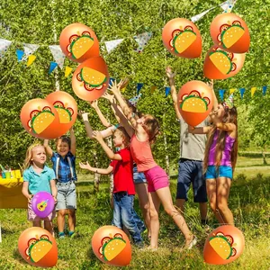 Happy children playing with orange taco print balloons for Cinco de Mayo party decoration.