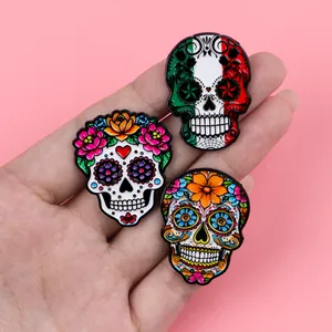 Close-up of vibrant Mexican sugar skull enamel pins with detailed floral patterns