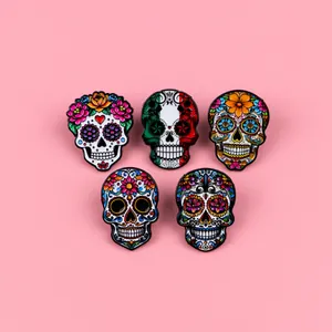 Vibrant set of five Mexican sugar skull enamel pins featuring floral and folk art patterns