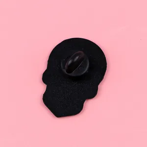 Close-up back view of a skull-shaped punk metal lapel pin featuring a black rubber clutch