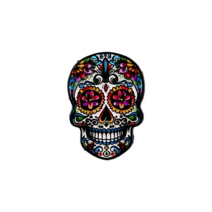 Close-up detail of a vibrant Mexican sugar skull enamel pin with intricate floral patterns