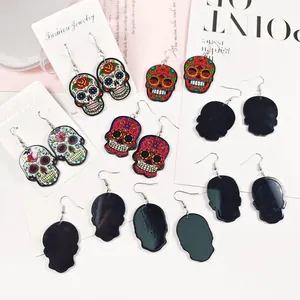 Détail de boucles d'oreilles punk en acrylique avec motifs de têtes de mort colorées