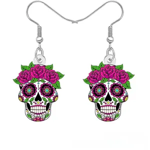 Macro detail of vibrant acrylic sugar skull earrings adorned with vivid pink roses and leaves
