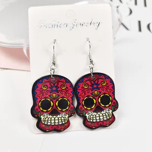 Détail de boucles d'oreilles tête de mort colorées sur une carte de bijoux blanche