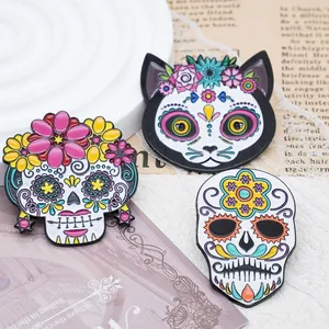 Close-up of three colorful Mexican Day of the Dead sugar skull and cat enamel pins