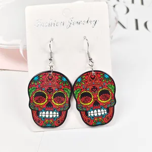 Détail de boucles d'oreilles tête de mort colorées aux motifs floraux de style punk