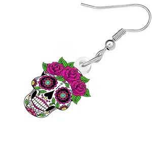 Detailed view of an acrylic sugar skull earring decorated with vibrant pink roses