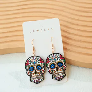 Detailed macro view of Mexican sugar skull earrings featuring vibrant floral patterns and motifs.