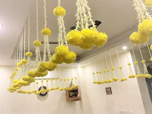 Beautiful artificial yellow marigold garlands hanging for Indian wedding and festival decor