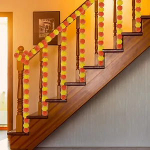 Vibrant artificial yellow and orange marigold garlands draped on a wooden staircase railing