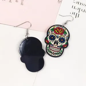 Détail des boucles d'oreilles tête de mort punk avec motifs floraux colorés imprimés