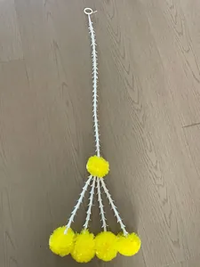 Full view of artificial yellow marigold garland with white trumpet flower vine.