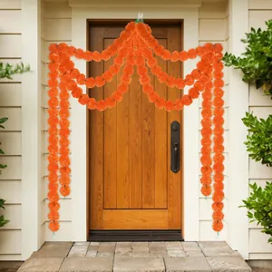 Decorative orange marigold flower garlands draped elegantly over a rustic wooden front door