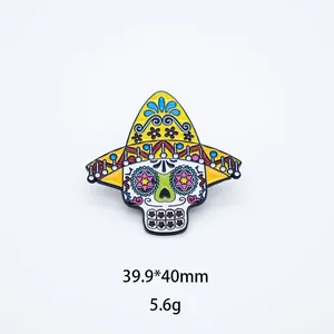 Close-up of Mexican sugar skull enamel brooch with yellow sombrero and colorful patterns