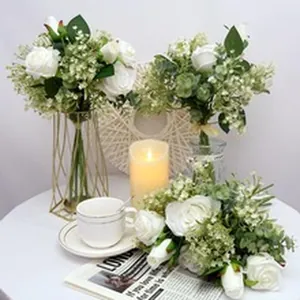 Elegant white artificial rose bouquet arranged with a candle and coffee cup for decor