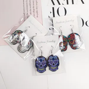 Gros plan de boucles d'oreilles crâne en acrylique coloré avec motifs floraux