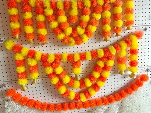 Detailed view of vibrant yellow and orange artificial marigold garlands with gold bells