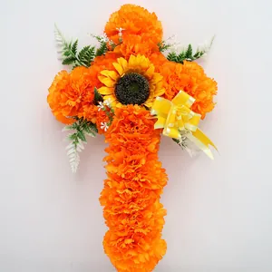 Künstliches Kreuz aus orangefarbenen Studentenblumen für Tag der Toten Dekoration.