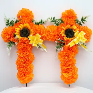 Detailansicht von zwei leuchtend orangefarbenen Ringelblumenkreuzen mit Sonnenblumen und Bändern