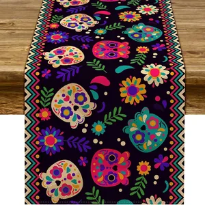 Day of the Dead table runner with colorful skull and flower patterns on wood table.