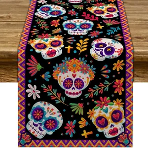 Vibrant Mexican sugar skull table runner with floral patterns on black linen fabric.