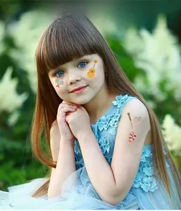 Detail of Day of the Dead themed temporary tattoos on a young girl for party