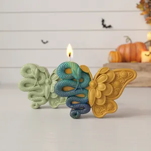 Dettaglio di una candela a forma di farfalla con serpente e intricati intagli floreali