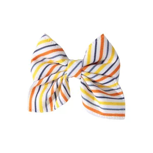 Close-up view of a striped hair bow featuring orange and yellow lines for Halloween party