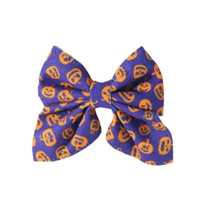 Macro view of purple bow hair clip featuring vibrant orange Halloween pumpkin patterns