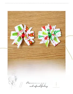 Detailed view of festive Christmas themed bow hair clips with holiday tree and gift patterns