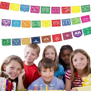 Colorful Mexican Papel Picado banner hanging above happy children at a birthday party